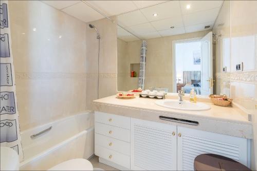 多列毛利诺斯Torremolinos Apartment的浴室配有水槽、淋浴和浴缸。