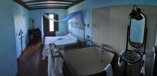 阿兰达德杜洛Hotel Rural y SPA Kinedomus Bienestar的一间带浴缸的浴室和一张位于客房内的床
