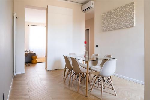 罗马Testaccio Design Apartment Rome的一间设有玻璃桌和白色椅子的用餐室