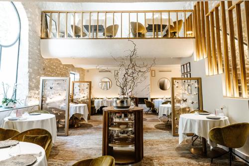 圣雷米普罗旺斯Auberge De Saint-Rémy - Hôtel - Restaurant Gastronomique Étoilé - Saint Rémy de Provence的一间带桌椅的餐厅,以及楼梯