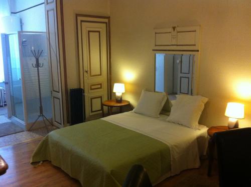 布鲁塞尔瑞斯登18号旅馆的一间卧室配有一张大床和两盏灯