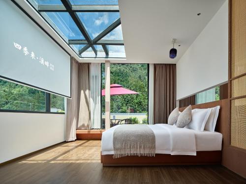 张家界Zhangjiajie Utopia Hotel的一间卧室设有一张床和一个大窗户