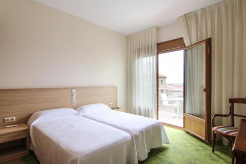 GuisonaHotel Cal Piteu的一间设有大床和窗户的酒店客房