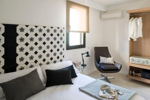 巴塞罗那埃里克维科尔精品公寓 - 圣家堂套房的卧室配有白色的床和黑椅