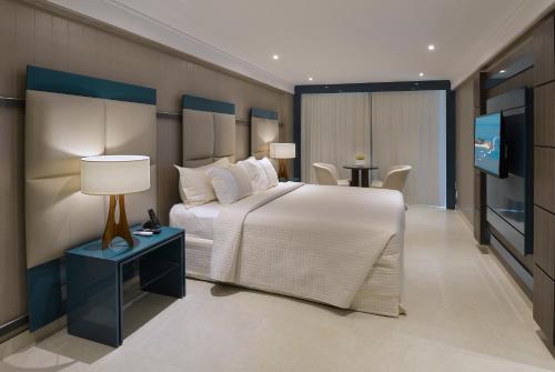 若昂佩索阿坦巴乌卢克索诺德酒店的一间卧室配有一张大床和一台平面电视