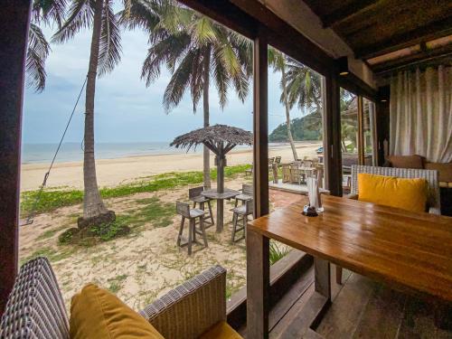 春蓬Chumphon Cabana Resort的海滩上带桌椅的房间