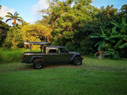 卡胡卢伊CampCar Maui Jeeps SUVs Hybrid Camper van Rentals with equipment and Travel Advice的停在草地上的绿色吉普车