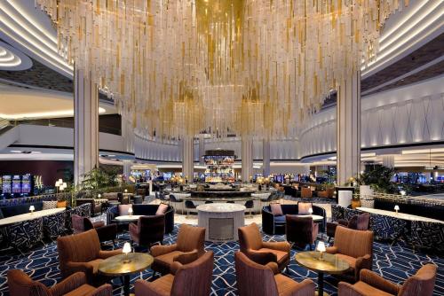 拉斯维加斯Fontainebleau Las Vegas by Suiteness的酒店大堂设有吊灯和桌椅