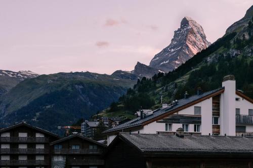 采尔马特SCHLOSS Zermatt - Active & CBD Spa Hotel的享有酒店和建筑的山景