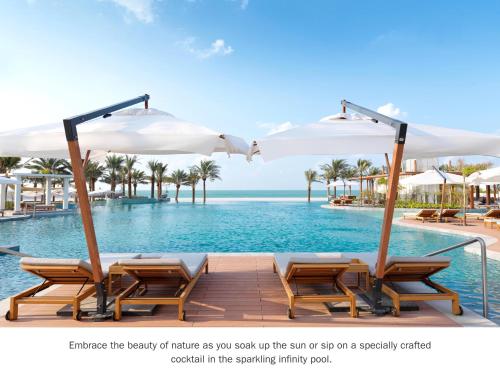 拉斯阿尔卡麦InterContinental Ras Al Khaimah Mina Al Arab Resort & Spa, an IHG Hotel的一个带椅子和遮阳伞的游泳池