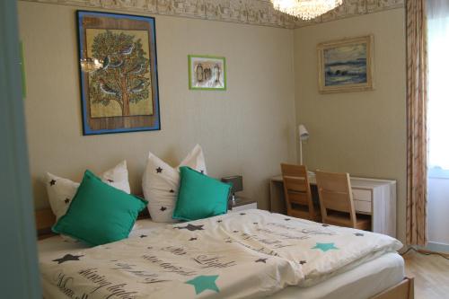 巴特迪尔海姆勒本艺术酒店的一间卧室配有一张带绿色枕头的床