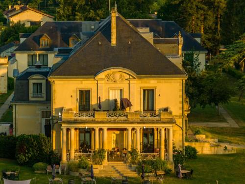 米尼亚卢博瓦尔Garrigae Manoir de Beauvoir Poitiers Sud - Hotel & Spa的大型白色房屋设有门廊和阳台