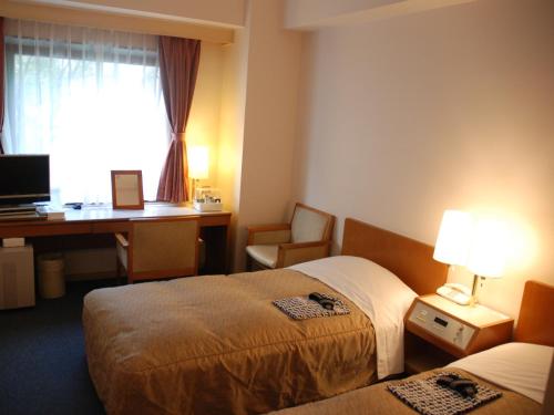 东京池袋新星酒店的酒店客房配有两张床和一张书桌