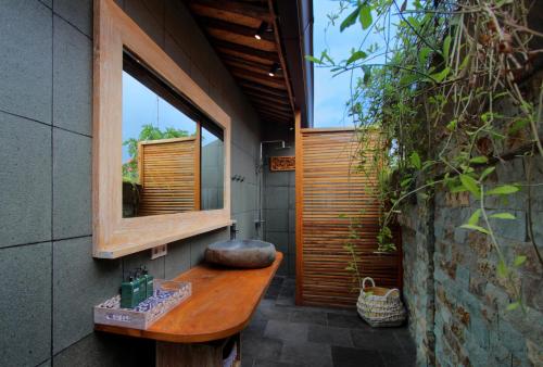 乌鲁瓦图瑜伽寻找者巴厘岛度假村的一间带水槽和镜子的浴室