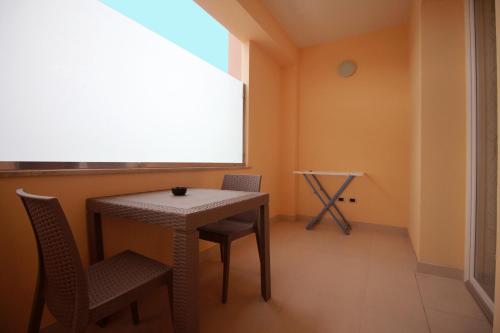 卡萨拉诺B&B Le Parmente的客房设有桌椅和窗户。