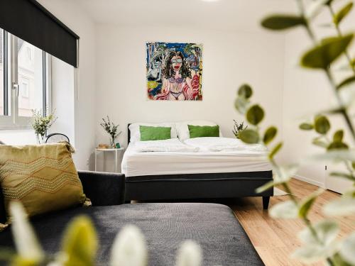 Straß in SteiermarkApartments nahe der Südsteirischen Weinstraße的卧室配有一张床,墙上挂有绘画作品