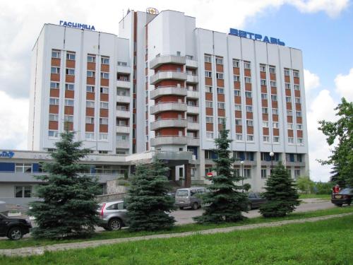 维捷布斯克Hotel Vetraz的停车场内停放汽车的大型建筑