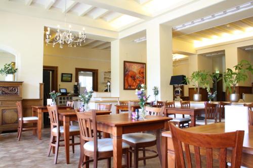滨海贝亨辉煌之家庄园的餐厅设有木桌、椅子和吊灯。
