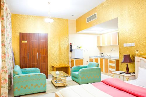 沙迦阿贝拉精品酒店的一间卧室配有一张床和两把椅子,还设有一间厨房