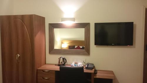 纽波特盖特威快捷酒店的客房设有带镜子的书桌和电视。