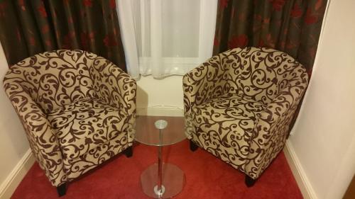 纽波特盖特威快捷酒店的两把椅子坐在带窗帘的房间