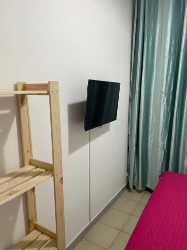 那不勒斯Hostel BB La Fenice的一间墙上配有电视的房间和梯子