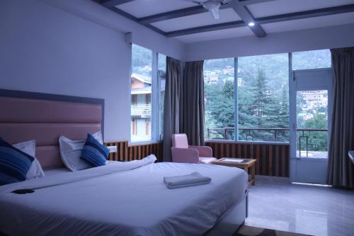 马拉里Preet Guest House In Old Manali with Mountain View的酒店客房设有一张床和一个大窗户