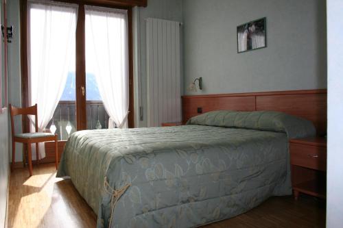 卡斯蒂奥内·德拉·佩雷索米格里奥拉蒂酒店的卧室配有床、椅子和窗户。