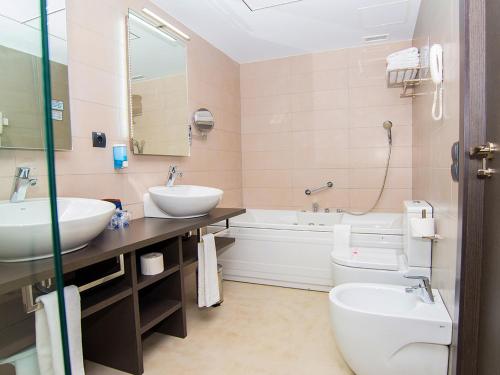 比纳罗斯维那罗斯RH灵气酒店的一间带两个盥洗盆、浴缸和卫生间的浴室