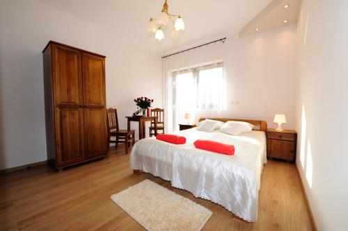 克拉科夫威拉朱莉娅旅馆的一间卧室配有一张带两个红色枕头的床