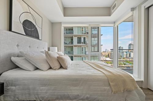 卡尔加里Modern Suite Calgary Downtown 5 min walk Stampede的一间卧室设有一张大床和大窗户