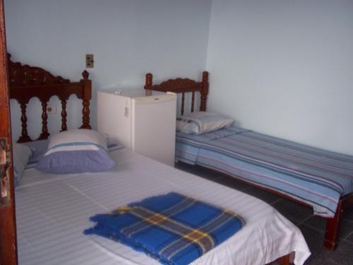 卡拉瓜塔图巴里亚舒谷宾馆的配有冰箱的客房内设有两张单人床。
