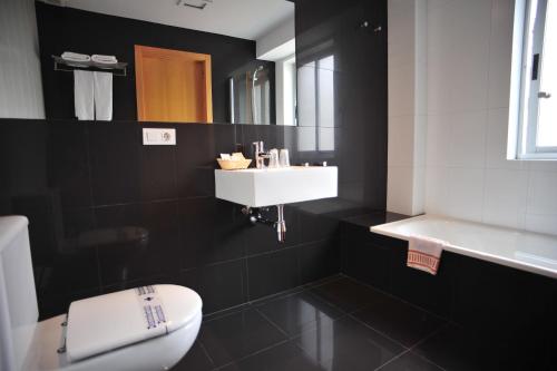 圣地亚哥－德孔波斯特拉温莎酒店的浴室配有白色水槽和卫生间。