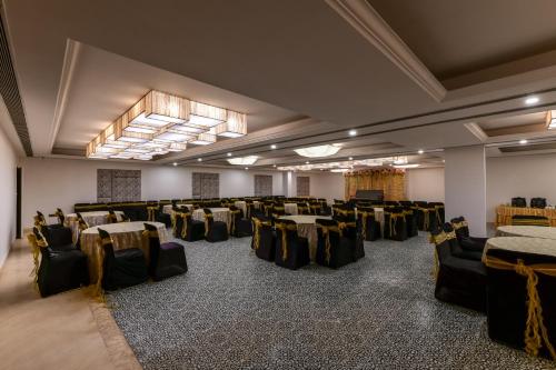 赖布尔Regenta Inn Downton Raipur的宴会厅,配有桌椅