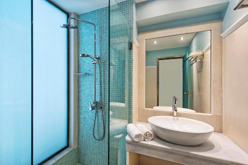 卡马利马卡里奥斯酒店的一间带水槽和玻璃淋浴的浴室