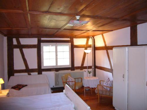 康斯坦茨沃尔豪森布尔霍夫民宿的一间带一张床的卧室和一间带木制天花板的房间