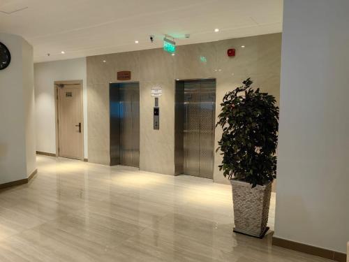 利雅德Al Furat Madayin Hotel的楼里带盆栽的走廊