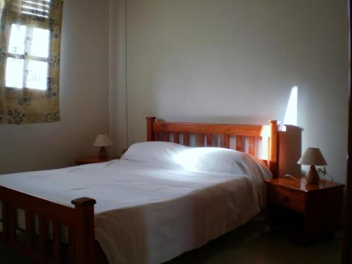勒马兰Abri Gens Libres的一间卧室配有一张带白色床单的床和一扇窗户。