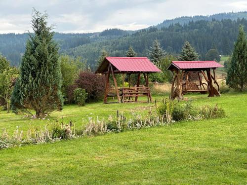 Plaiu ŞaruluiCabana La Plai Vest - cozy private place in the mountain的两座木凉亭,位于一个树木繁茂的田野