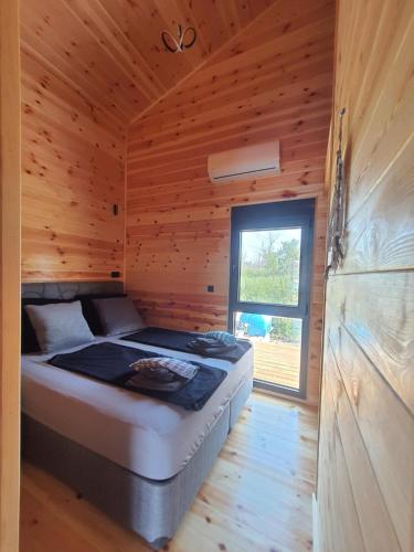 乌尔齐尼modernes Holzhaus, Cabin, auf dem Fluss, wenige Meter zum Meer的小木屋内一间卧室,配有一张床