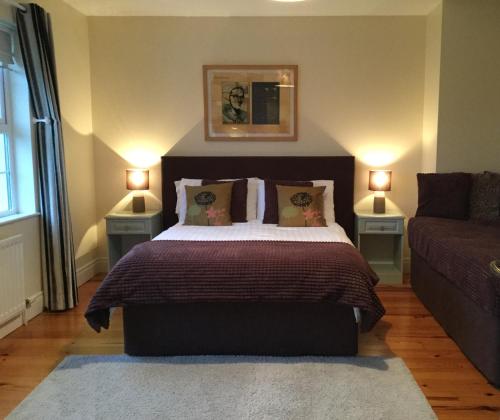波塔当Cherryville House的一间卧室配有带2个床头柜和1张沙发的床