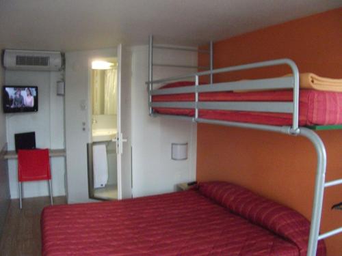 巴约讷普瑞米尔巴永纳经典酒店的一间卧室配有一张带红色床罩的双层床
