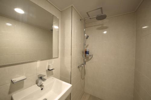 济州市海港酒店的白色的浴室设有水槽和淋浴。