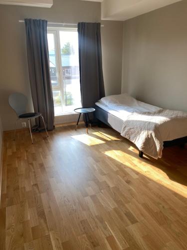 巴杜弗斯Modern apartment in Bardufoss Center - two bedrooms, garage, terrace的一间卧室配有一张床、一张桌子和一个窗户。