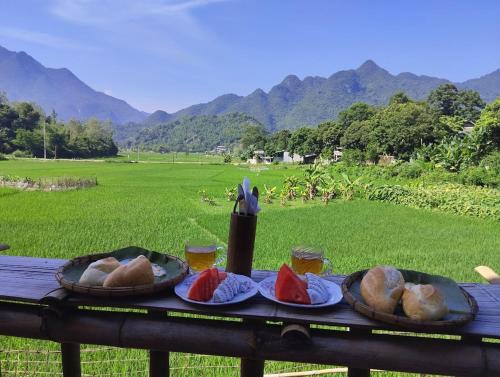 枚州县Meadow Mai Chau Homestay的一张桌子上放有面包和西瓜盘