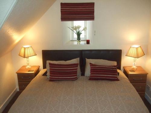 洛西茅斯Links Lodge的一间卧室配有一张大床和两盏灯