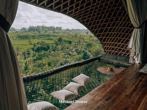 SelatCamaya Bali - Magical Bamboo Houses的客房设有带枕头的景观阳台。