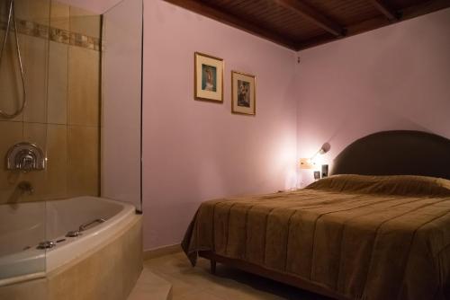 比雷埃夫斯阿尔法酒店的卧室配有床和浴缸,毗邻一个sidx sidx sidx床