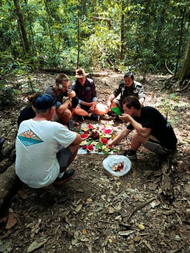 武吉拉旺Jungle View Homestay & Guesthouse的一群坐在树林里吃食物的人