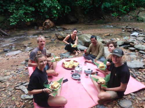 武吉拉旺Jungle View Homestay & Guesthouse的一群人坐在野餐桌旁